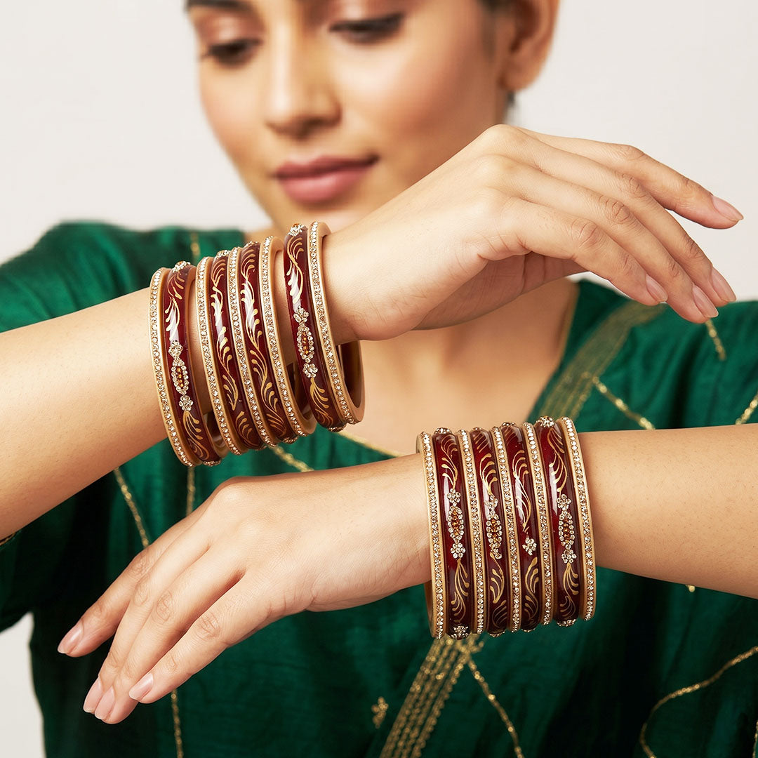 Handcrafted Rajasthani short lac bangles with golden leaf handpainting and rhinestone detailing, premium Jaipur bangles set of 18 for women in glossy maroon.